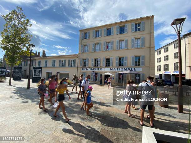 Piétons et touristes avec des masques devant le batiment de la Gendarmerie Nationale, le 16 aout 2020 à Saint-Tropez.