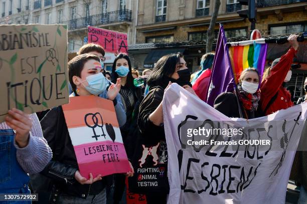 Pancarte "Lesbienne et fière" et banderole "Collages lesbiens" lors de la journée internationale des droits des femmes le 8 mars 2021 à Paris.
