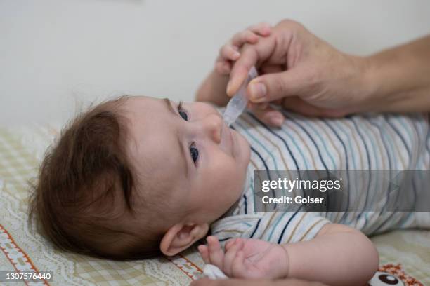 baby taking droplet vaccine to prevent rotavirus - vitamin drip stock pictures, royalty-free photos & images