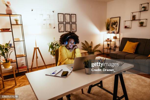 young african american woman has video call with colleagues - home office stock pictures, royalty-free photos & images