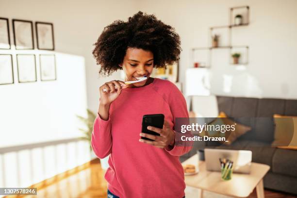 junge afroamerikanische frau zähneknirschend und mit telefon für die arbeit - brush teeth phone stock-fotos und bilder