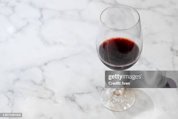 glass of red wine put on white marble table - verre vin rouge photos et images de collection