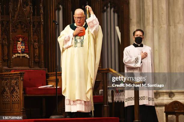 Cardinal Timothy Dolan, Archbishop of New York, sings along to the National Anthem after the conclusion of a St. Patrick's Day Mass at St. Patrick's...