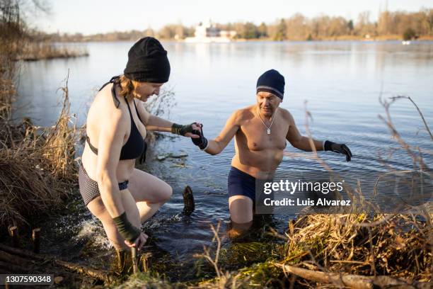 couple in lake for swimming on a winter day - winter sport walk old stock pictures, royalty-free photos & images