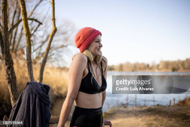 woman shivering after a swim in the freezing cold lake - red swimwear stock pictures, royalty-free photos & images