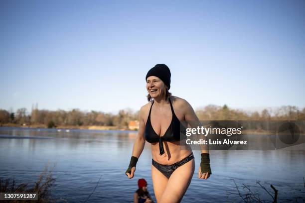 smiling woman coming out of the lake - people coming of age purify with icy water in tokyo stockfoto's en -beelden