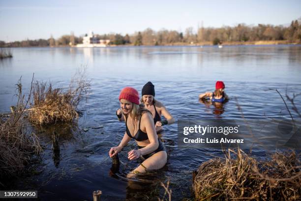 women coming out of lake after a swim - woman shivering stock pictures, royalty-free photos & images