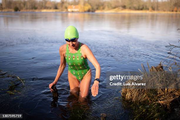 mature female swimmer coming out of lake - people coming of age purify with icy water in tokyo stockfoto's en -beelden