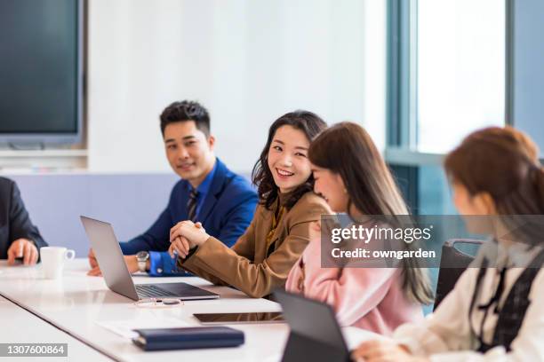 business colleagues discussing in the meeting room - chinois affaire photos et images de collection