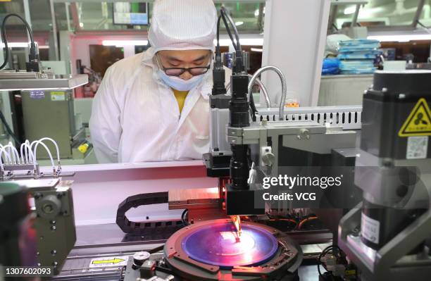 Employees work on the production line of silicon wafer at a workshop of Jiejie Semiconductor Co., Ltd on March 17, 2021 in Nantong, Jiangsu Province...