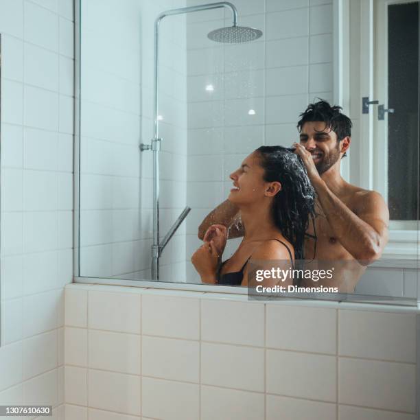 couple taking a shower and washing hair in the bathroom at home - shower man woman washing stock pictures, royalty-free photos & images