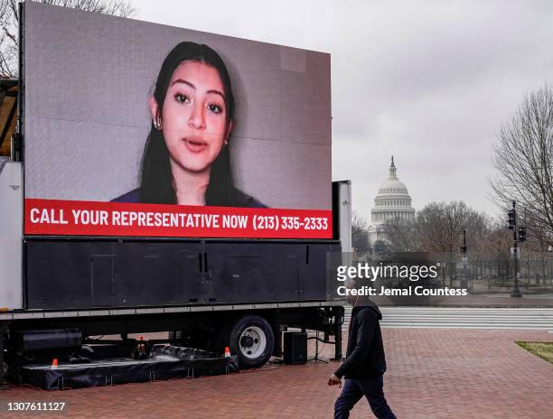 Man walks to the U.S. Capitol past an installation outside Union Station demanding a Yes vote on the American Dream and Promise Act and the Farm...