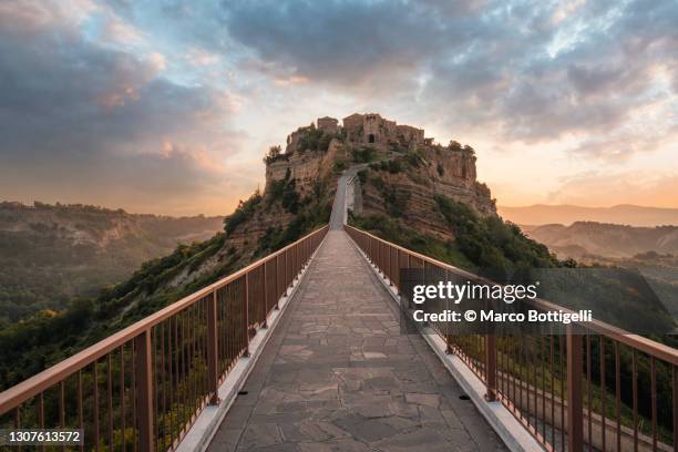 footbridge to perched medieval town - étroit photos et images de collection