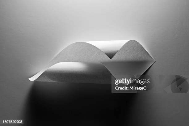 light and shadow on curled up paper monochrome - curled up stock pictures, royalty-free photos & images