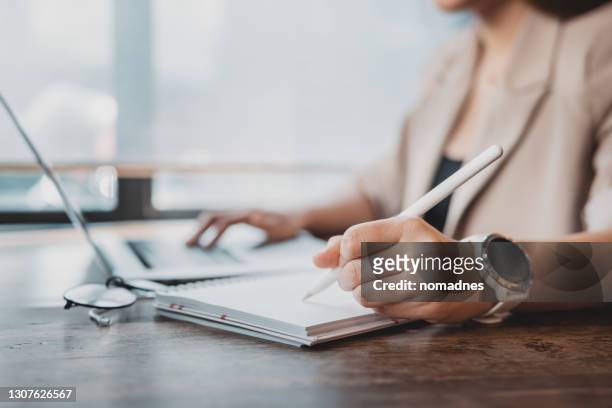 woman working with laptop computer and documents.hands at work with digital technology.working on desk environment.analog working with documents. - writing stock pictures, royalty-free photos & images
