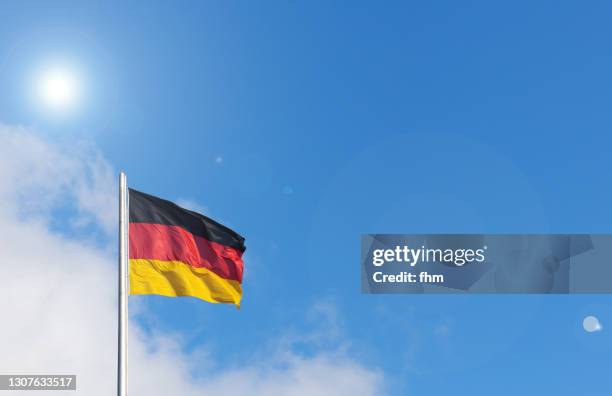 german flag with blue sky and bright sun - tysklands flagga bildbanksfoton och bilder