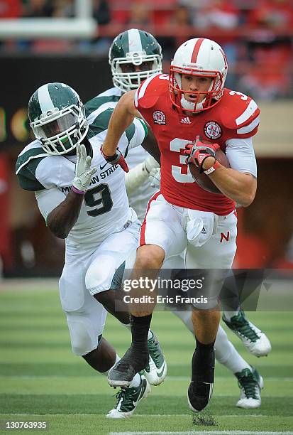 Quarterback Taylor Martinez of the Nebraska Cornhuskers runs away from safety Isaiah Lewis of the Michigan State and the rest of the Spartan defense...