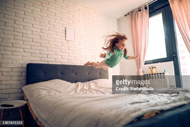 ich bin allein zu hause - children jumping bed stock-fotos und bilder