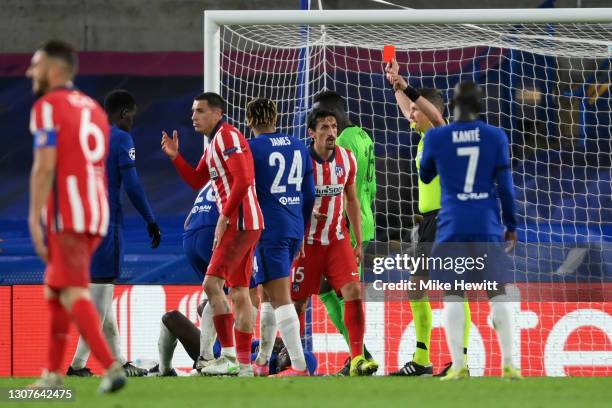 Stefan Savic of Atletico Madrid is shown a red card and sent off by referee Daniele Orsato for a clash with Antonio Ruediger of Chelsea during the...