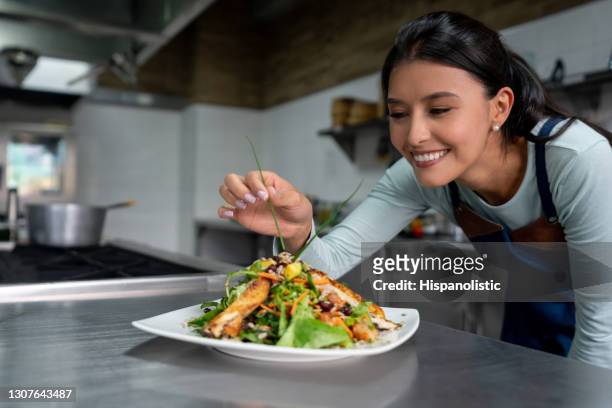 chef working at a restaurant and decorating a plate in the kitchen - chef finishing stock pictures, royalty-free photos & images