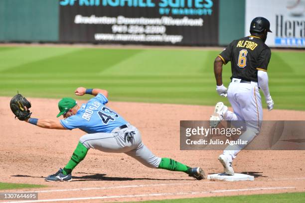 Anthony Alford of the Pittsburgh Pirates reaches first base before Michael Brosseau of the Tampa Bay Rays can make the tag in the fifth inning of a...
