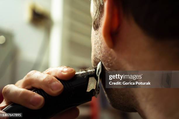 man using electric razor for beard - electric razor stock pictures, royalty-free photos & images