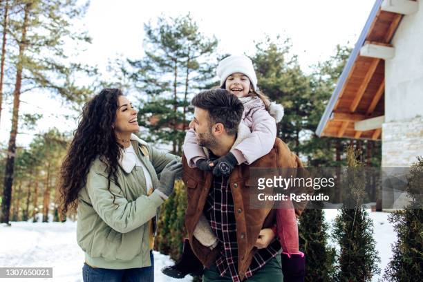 gelukkige familie die pret tijdens hun de wintervakantie heeft - winter stockfoto's en -beelden