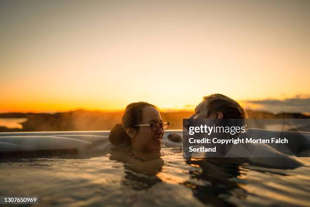 romantic hot tub date with a young man and woman - bathing in sunset stock pictures, royalty-free photos & images