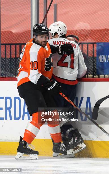 Andy Andreoff of the Philadelphia Flyers battles against Garnet Hathaway of the Washington Capitals at the Wells Fargo Center on March 11, 2021 in...