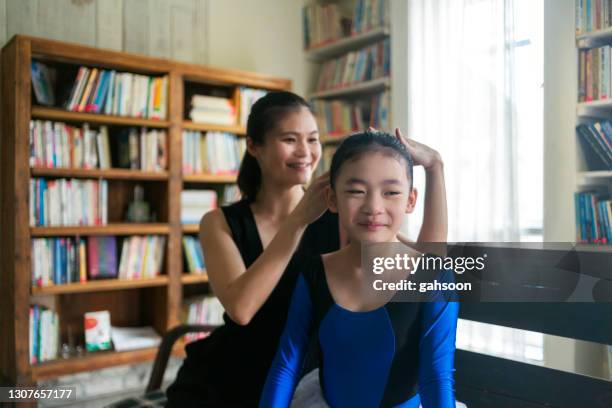 mother doing a hair style to to daughter before ballet class - bun hair woman stock pictures, royalty-free photos & images