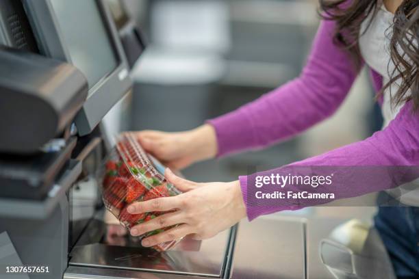 foto conceptual de una mujer escaneando fresas en el servicio de auto-pago de la tienda de comestibles - barcode scanner fotografías e imágenes de stock