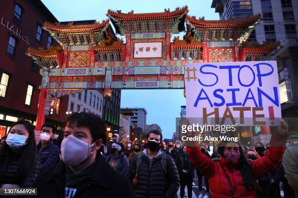 Activists participate in a vigil in response to the Atlanta spa shootings March 17, 2021 in the Chinatown area of Washington, DC. A gunman opened...