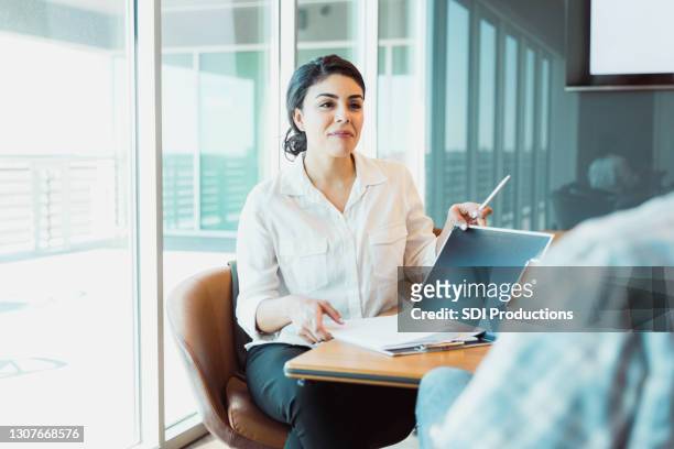 confident female business owner listens to man - case manager stock pictures, royalty-free photos & images