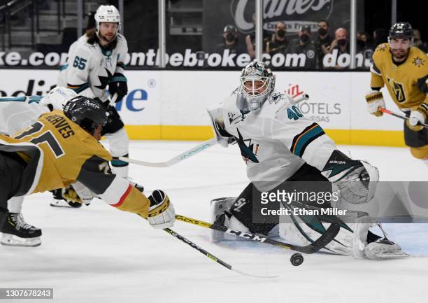 Devan Dubnyk of the San Jose Sharks makes a save as Ryan Reaves of the Vegas Golden Knights tries to score on a rebound in the second period of their...