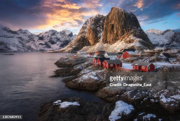 vista nocturna de la famosa atracción turística hamnoy pueblo de pescadores en las islas lofoten, noruega con casas rorbu rojas en invierno - lofoten fotografías e imágenes de stock