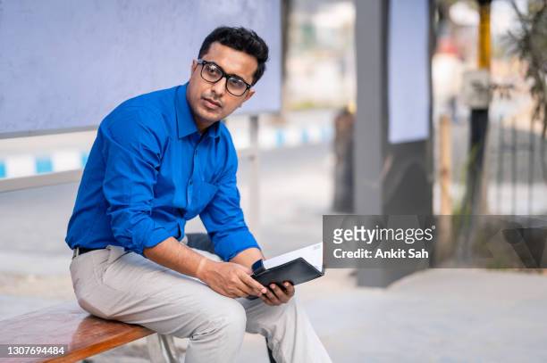 young businessman waiting at bus stop - indian politics and governance stock pictures, royalty-free photos & images