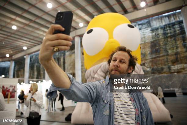 Musician Ben Lee takes a selfie with the inflatable installation 'Homer Homer' at the opening night of The Other Art Fair at Barangaroo Reserve on...