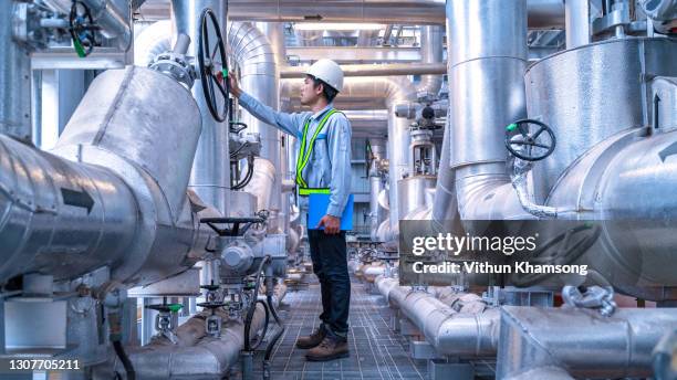 engineer working at industrial zone for operate equipment, steel pipelines and valve - oil and gas workers stock-fotos und bilder