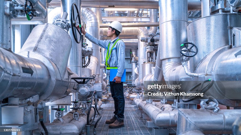 Engineer working at industrial zone for operate equipment, Steel pipelines and valve