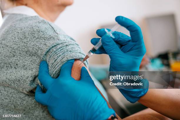 patient getting vaccination at home - aged care vaccine stock pictures, royalty-free photos & images