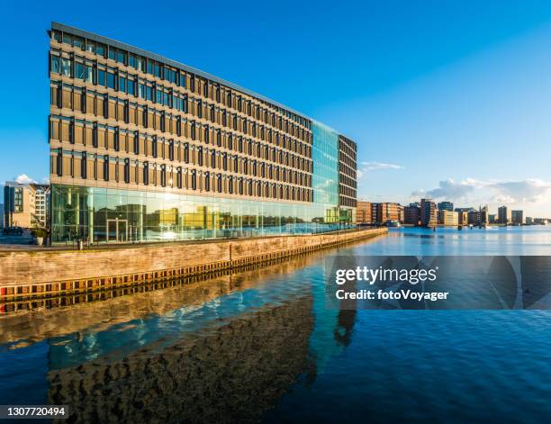 modern office building overlooking harbor waterfront at sunrise copenhagen denmark - denmark skyline stock pictures, royalty-free photos & images