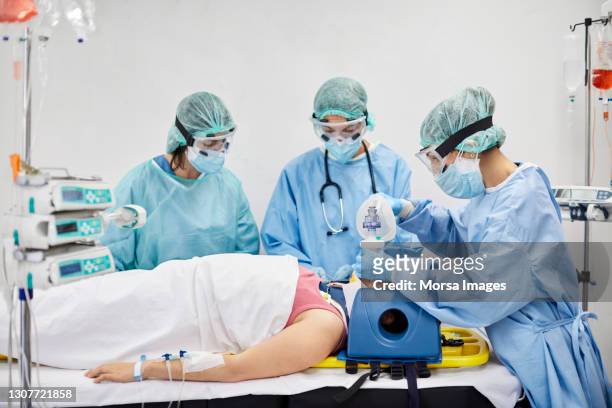 chirurghi che intubano il paziente in terapia intensiva durante il covid-19 - intubation foto e immagini stock
