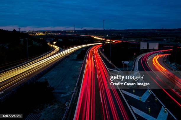 car traffic lights on the highway at sunset. long exposure shooting. yellow, red and orange lights. - car light trails stock pictures, royalty-free photos & images