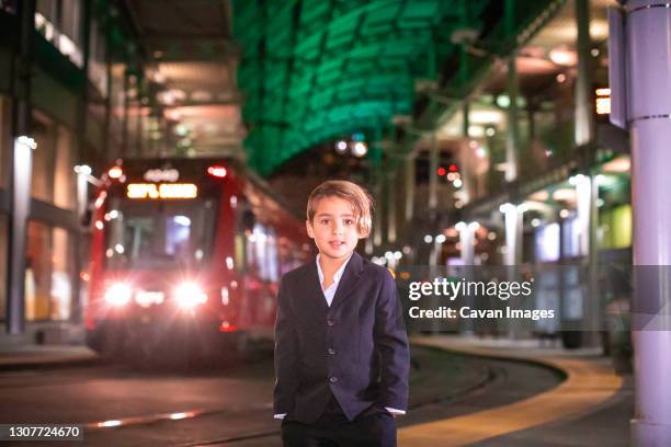 boy wearing suit standing at train station in downtown. - san diego trolley stock pictures, royalty-free photos & images