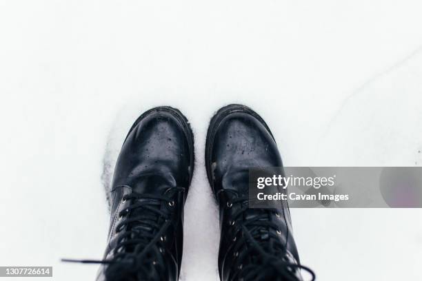 black boots in the snow - black boot stock pictures, royalty-free photos & images