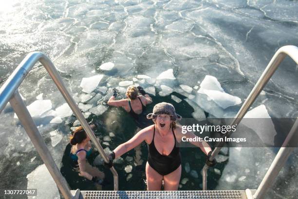three woman winter swimming in ice on a sunny day in copenhagen - selandia fotografías e imágenes de stock