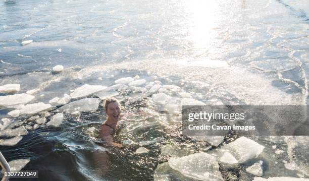 happy woman treading water with ice in the ocean in denmark - female swimmer bildbanksfoton och bilder