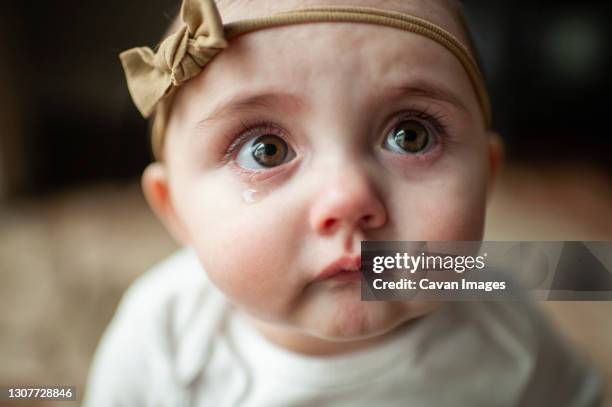 close up of sad baby girl with pouting lips and big tearful eyes - hair band stock pictures, royalty-free photos & images