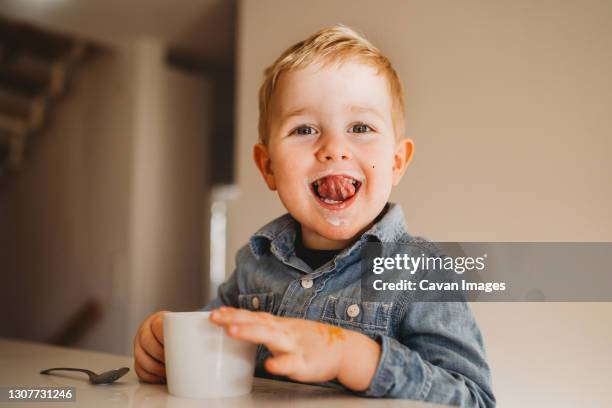 adorable white boy with milk moustache smiling with tongue out - hot chocolate stock pictures, royalty-free photos & images