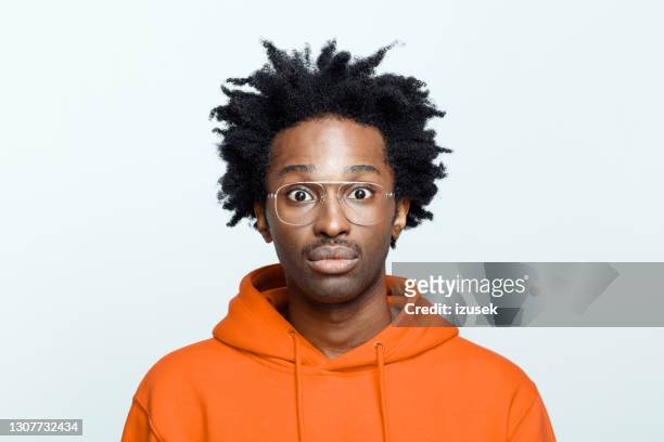 confused man in orange hoodie - surprised man stock pictures, royalty-free photos & images